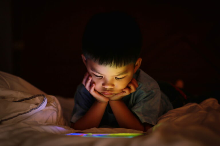 Jeune garçon regardant un iPad la nuit